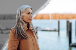 A woman looks out on the water, deep in thought