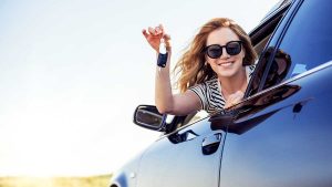 How to buy your first car - young woman with cars