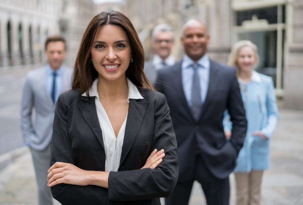 Successful business woman leading a group and looking at the camera smiling