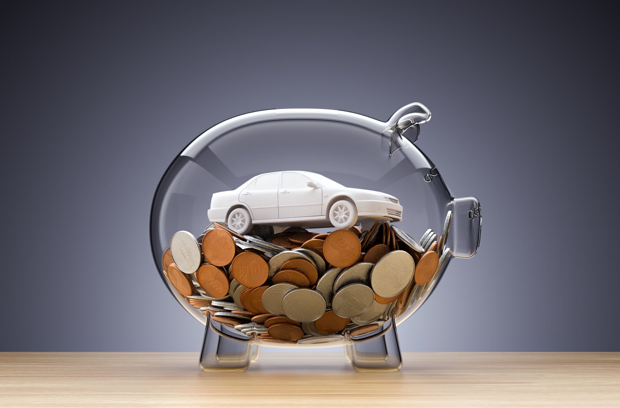 Model Car on money inside transparent piggy bank