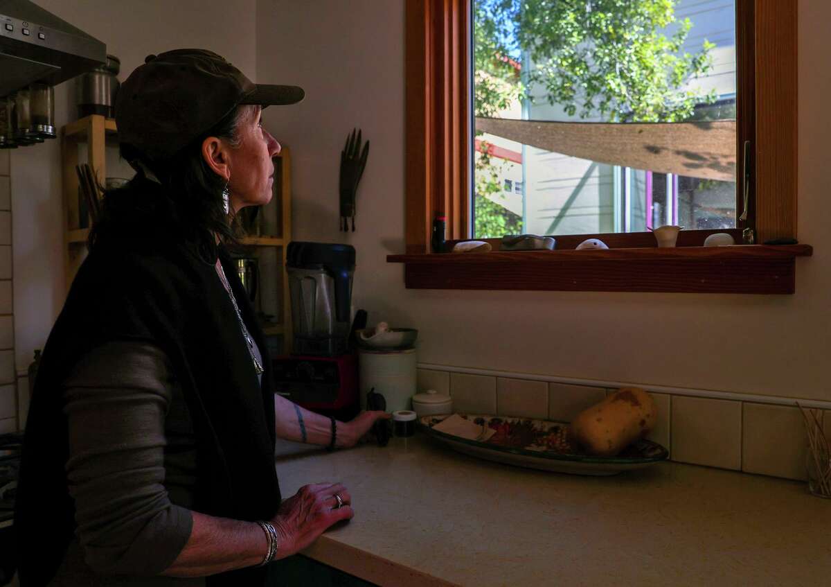 Susan Marchionna looks at her Berkeley house, which she’s rented out to long-term tenants for the past four years, from the granny unit where she lives in the backyard. She’s considering selling the house while she waits for answers from a state rent relief program for a tenant who has not paid rent in several months.