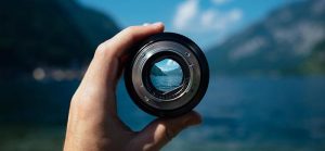 Image of camera lens focusing on mountain lake for Quotacy blog Things to Look for When Shopping Online for Life Insurance.