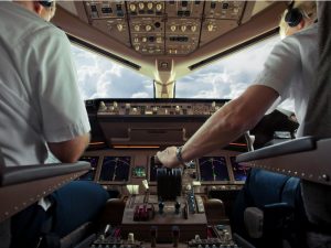 Two pilots seated in the cockpit of an airplane.