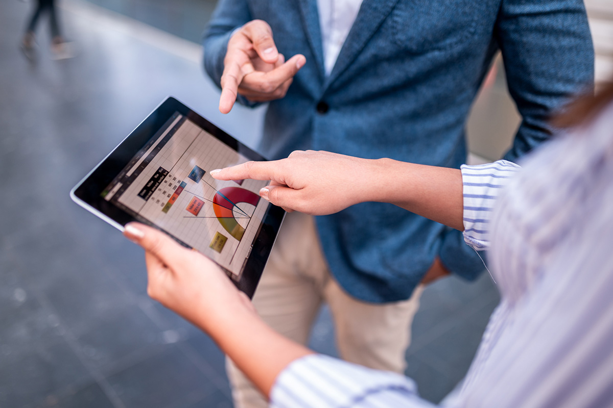 Two people look over data visualizations on a tablet