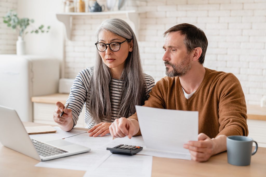 A wife and husband go over bills on their computer