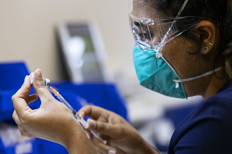 A health care worker prepares a Pfizer vaccine in the pharmacy of the Heidelberg Repatriation Hospital vaccination hub in Melbourne, Monday, September 13, 2021.