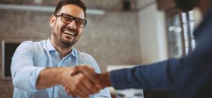 middle aged man shaking co-worker's hand at work