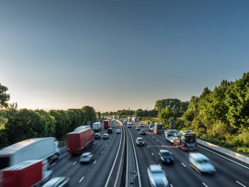 Highway with speeding traffic at sunset.