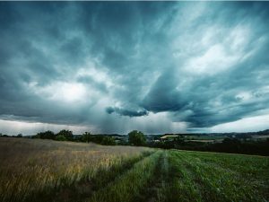 Storm cloudscape over grass field