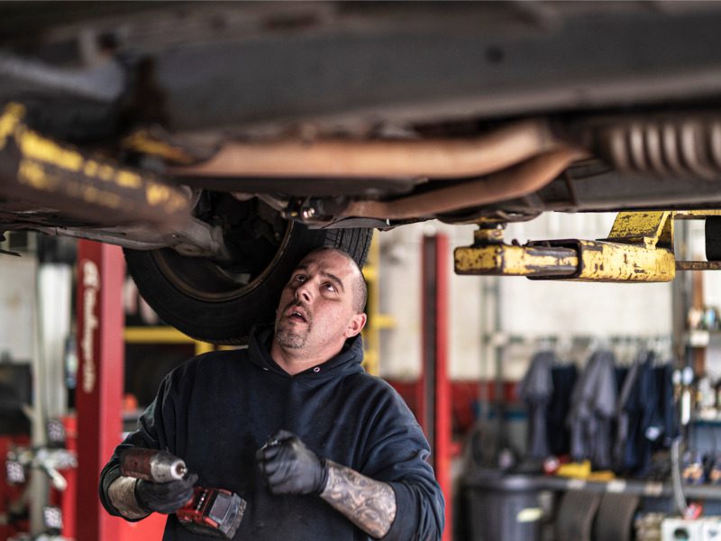 Mechanic working on the underside of a vehicle