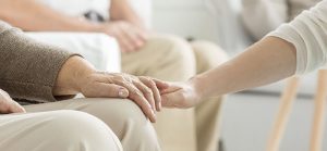 elderly woman's hand being held by younger person