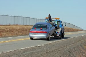 Tow Truck Towing A Vehicle On A Two Lane Highway