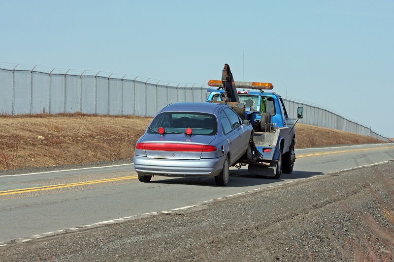 Tow Truck Towing A Vehicle On A Two Lane Highway