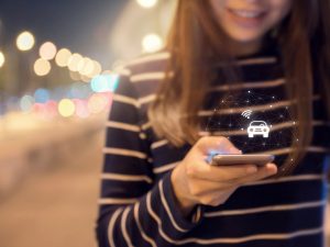 A woman ordering from a car-sharing platform on smartphone