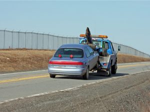 Tow truck towing a vehicle on a two-lane highway