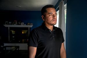 A photo shows Armando Peniche Rosales standing at home, facing the right. A window on the right casts the left side of his face in shadow.