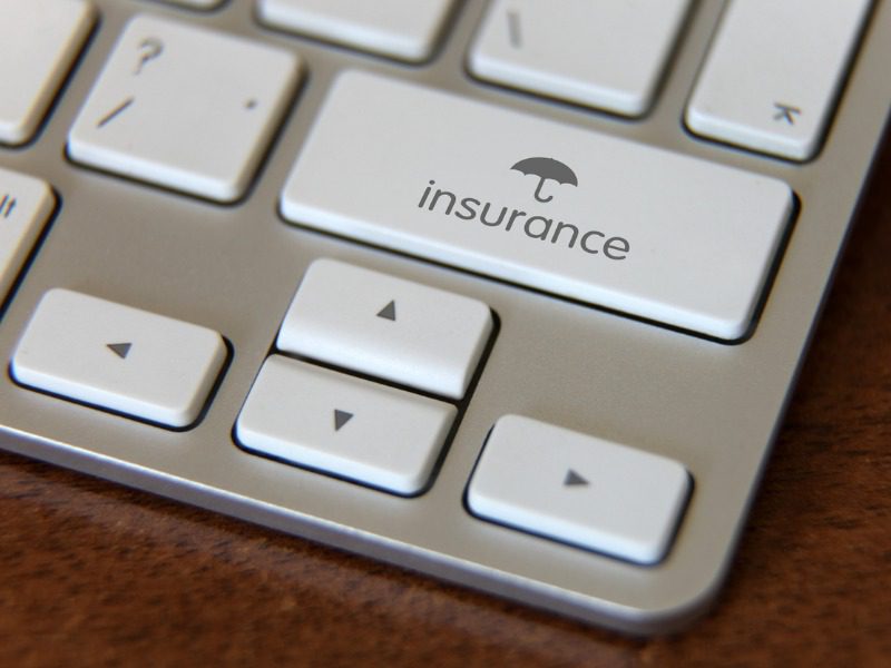 A close up shot of a laptop. One of the keys reads "insurance" and has an umbrella symbol on it.