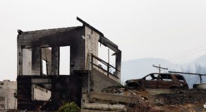 Fire Debris of Houses in a small town with smoke in sky.