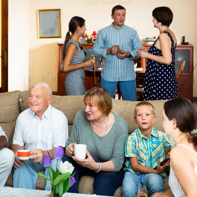 Grandparents, their children and grandchildren hang out in a home. (Image: Shutterstock)