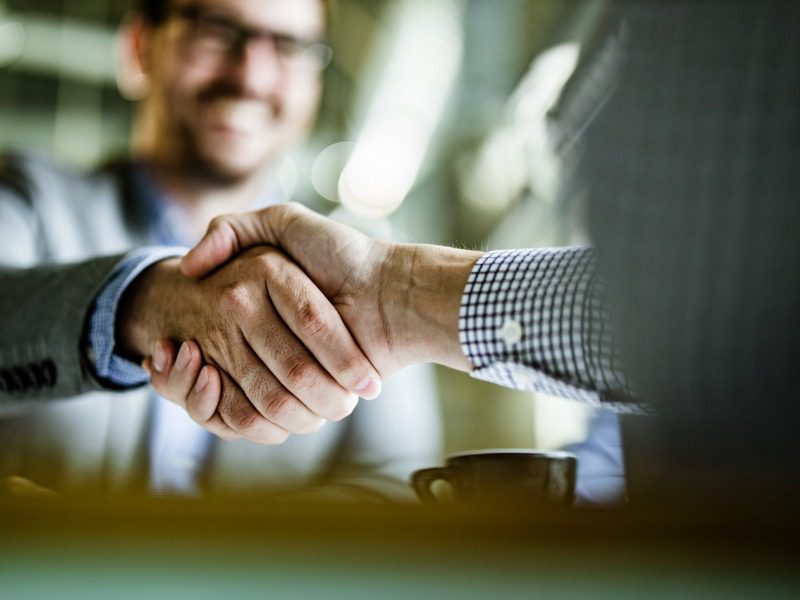 Close up of unrecognizable businessmen shaking hands on a meeting in the office.