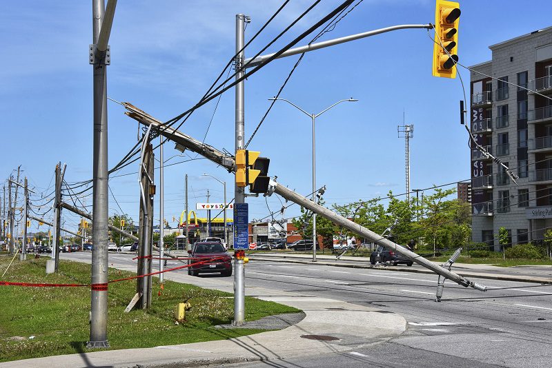 Ottawa, Canada - May 25, 2022: A row of power line poles that snapped on Merivale Road, a busy street in the west end of Ottawa. A severe storm known as a derecho passed through the area causing a lot of damage and power outages May 21.