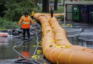 Workers sandbag around a restaurant in Calgary in anticipation of heavy rainfall