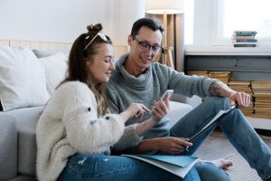 Cheerful partners sharing phone at home