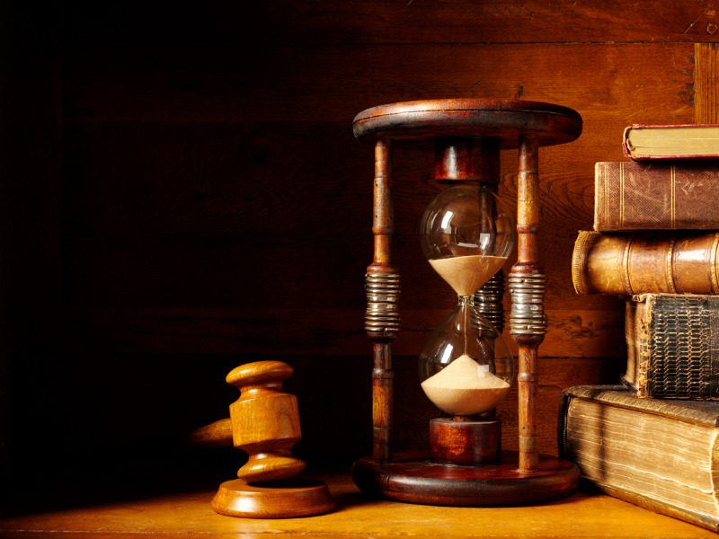 Gavel with an hourglass and antique books