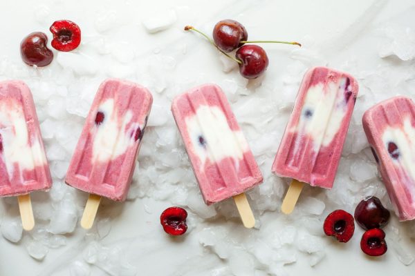 Lollies with cherries and ice on white table