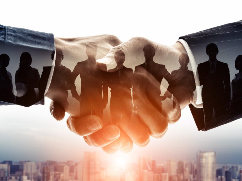 Group of businesspeople shaking hands representing an M&A deals