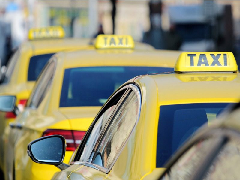 Three yellow taxi cabs lined up on the street