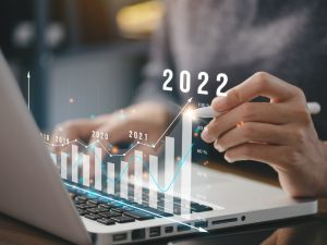 A person uses a stylus on their laptop to draw a bar graph showing a year by year increase