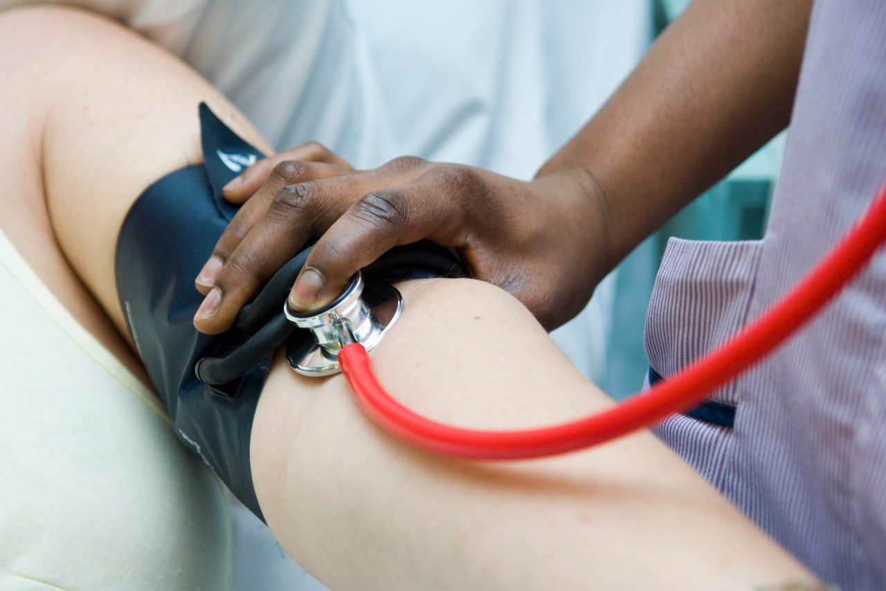 A photo shows a patient's blood pressure being checked with an arm cuff.