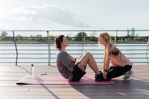 Young man with tattoos doing core workout on the dock