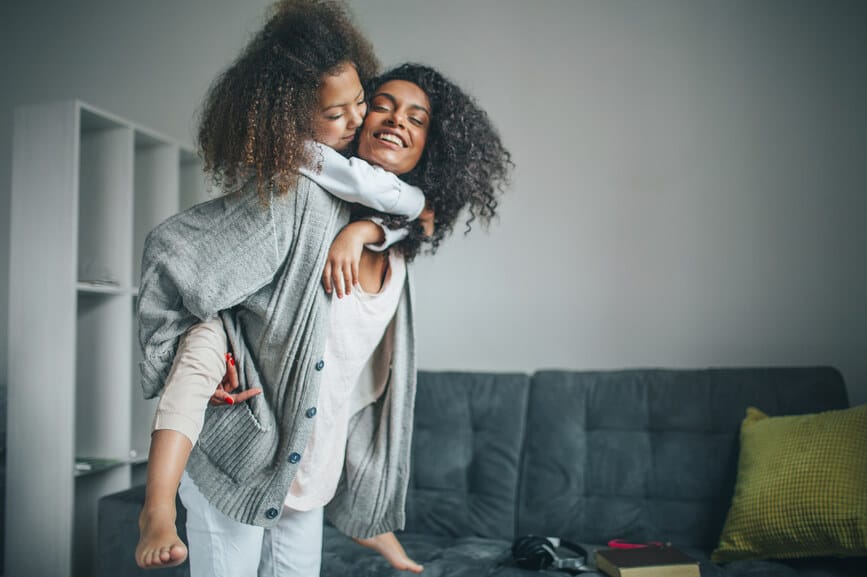 Young beautiful woman having fun with her daughter at home