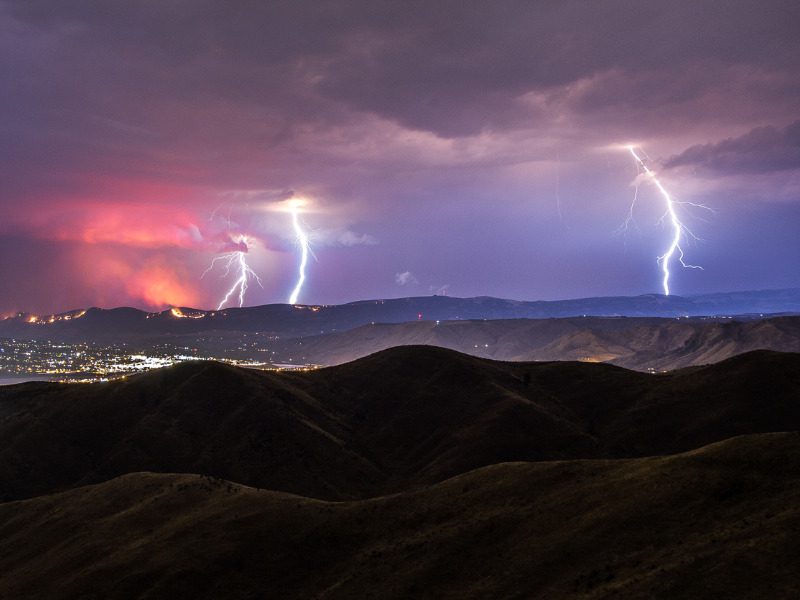 Multiple lightning strikes over a wildfire