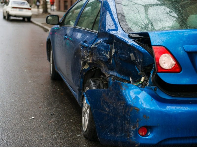 A blue car bumper is smashed