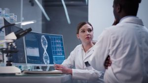 Diverse scientists studying DNA. Using computers and microscopes. Modern laboratory interior