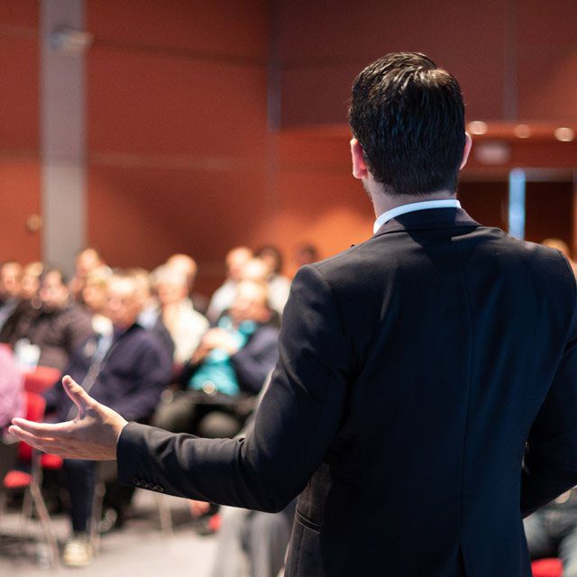 Speaker on stage at an industry conference