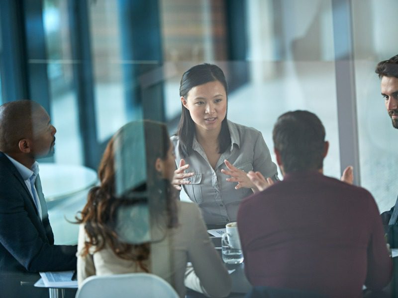 Cropped shot of a group of five businesspeople sitting in a meeting