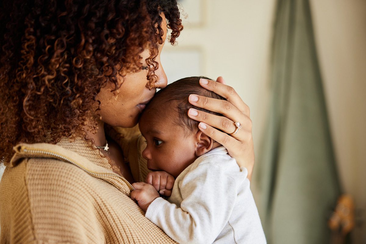 A mother kisses and cradles her baby