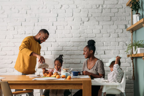 A family eating breakfast at a kitchen table together