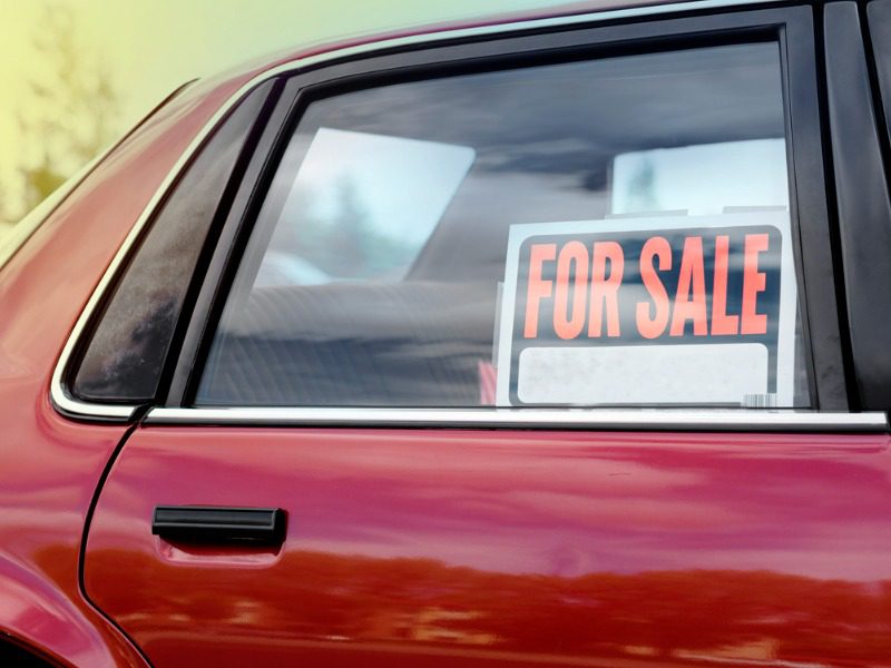 Used car with for sale sign in window