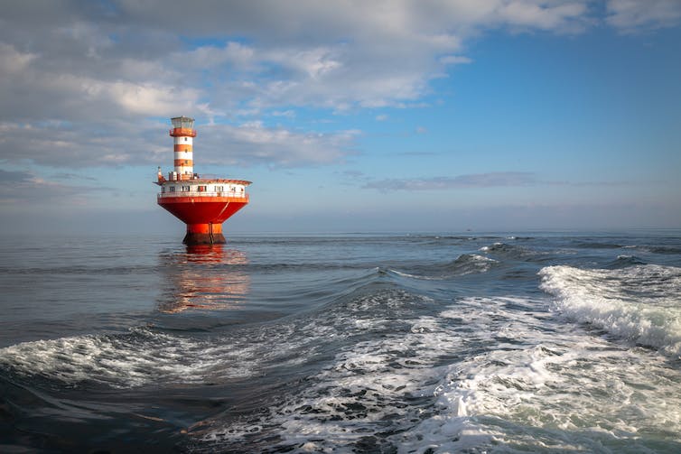 Un phare rouge et blanc dans une étendue d’eau