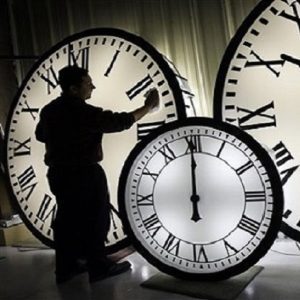 A clock caretaker polishing shadowy old clock faces. (Image: Elise Amendola/AP)