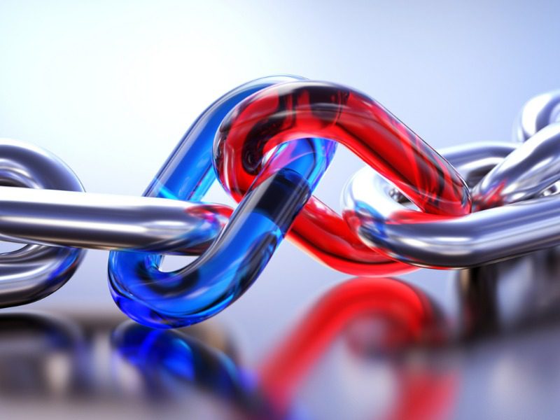 A row of silver chain links connected in the middle by one red and one blue chain