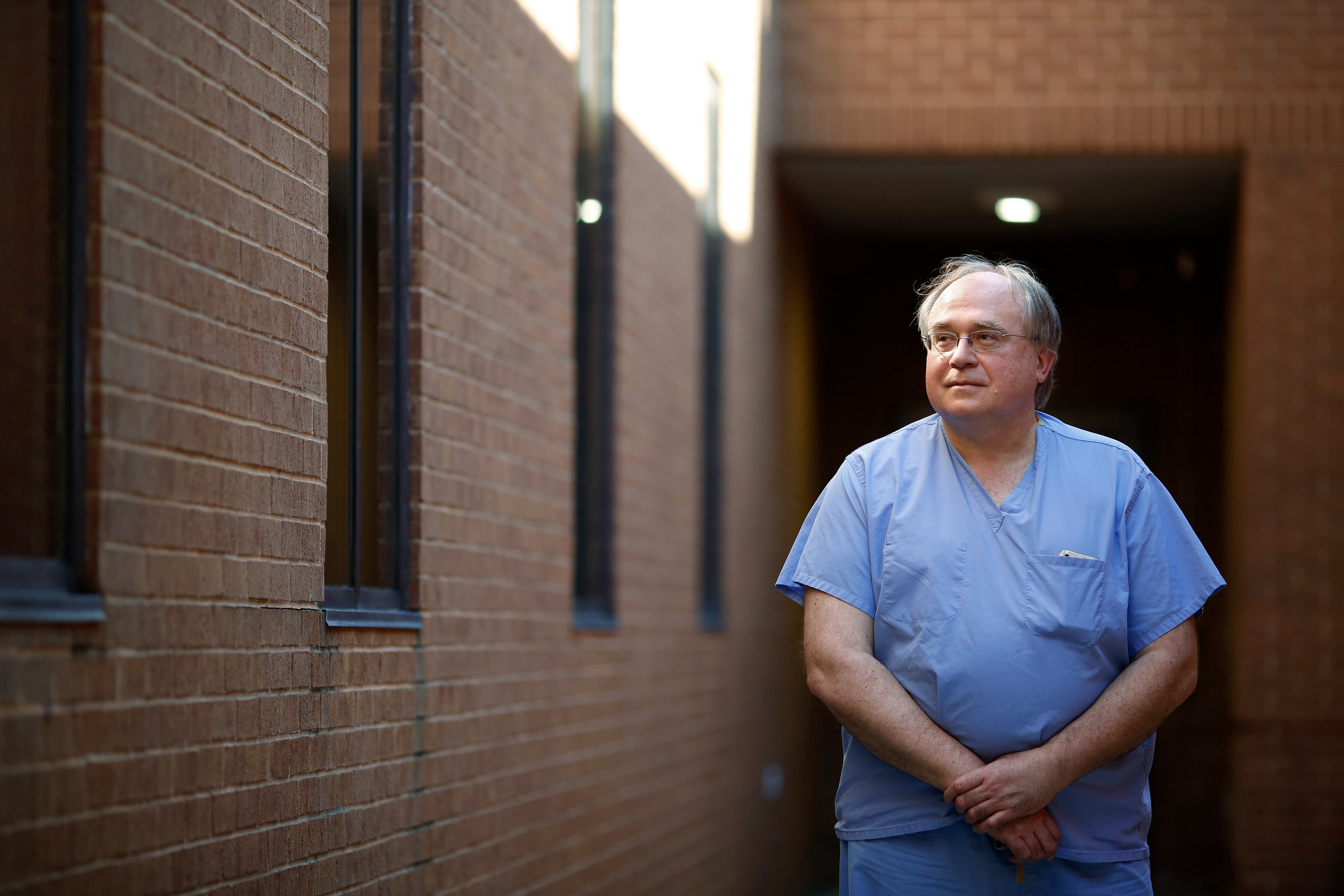 A photo shows Dr. Andrew Bush standing outside of his medical practice.