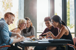 Students talking whilst sat at a table 