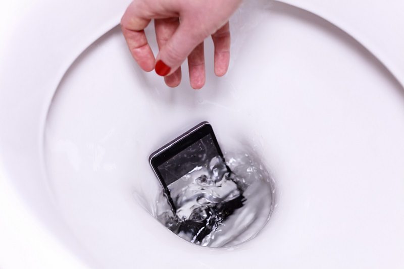 Hand Reaching into Toilet to Retrieve a Mobile Phone