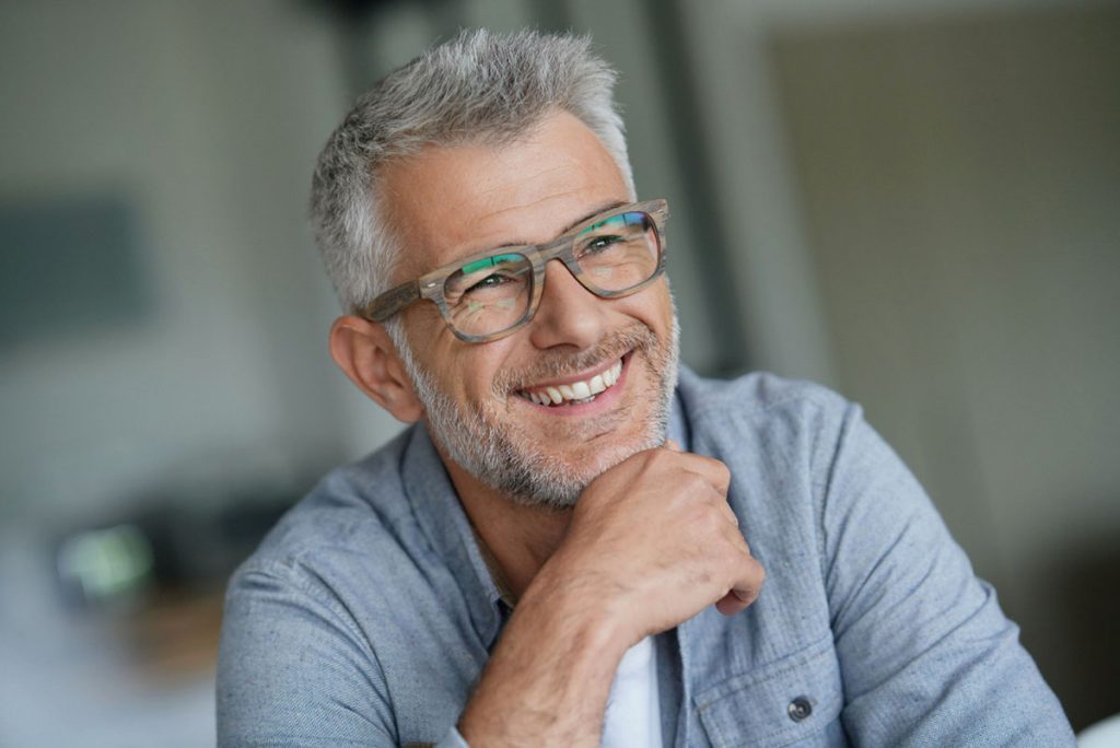 Older man with glasses smiling